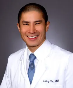 Orthopedist Dr. Erling Ho smiling in his white coat and slate blue tie