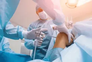 Surgeons perform minimally invasive knee surgery using medical instruments in an operating room.