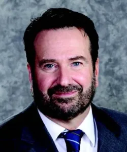 Orthopedist Dr. Scott A. Seymour with a soft smile wearing a clue suit and tie